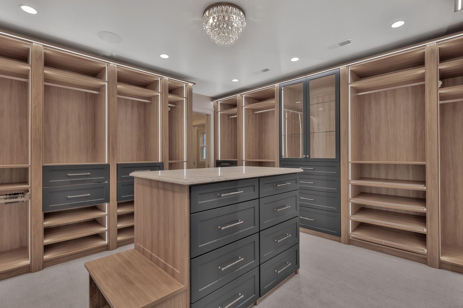 A large walk in closet with lots of drawers and shelves.