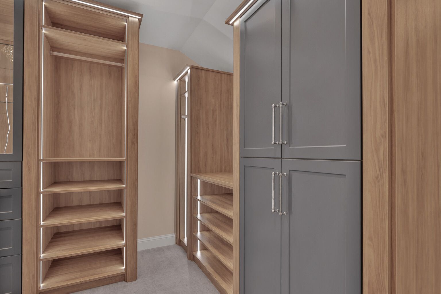 A walk in closet with wooden shelves and gray cabinets.