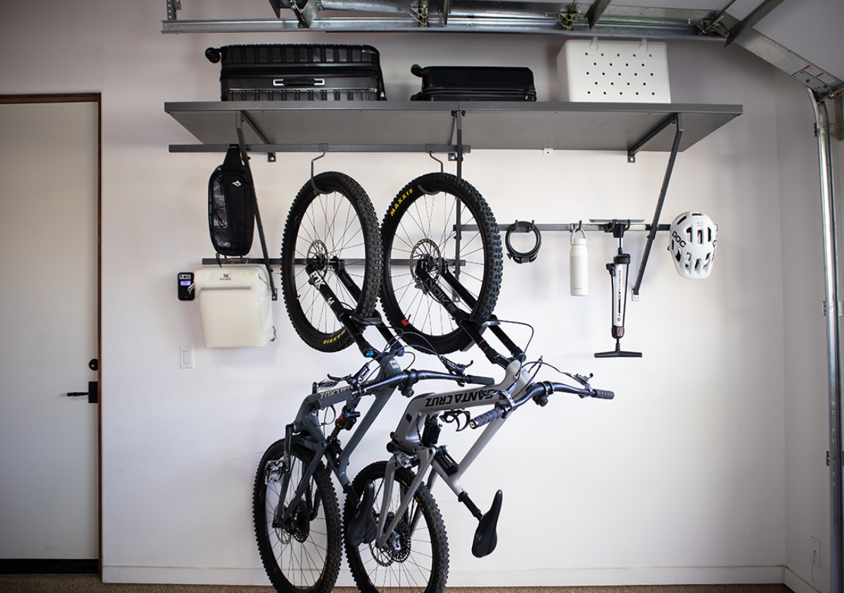 Garage wall with bikes, equipment, and storage shelves.