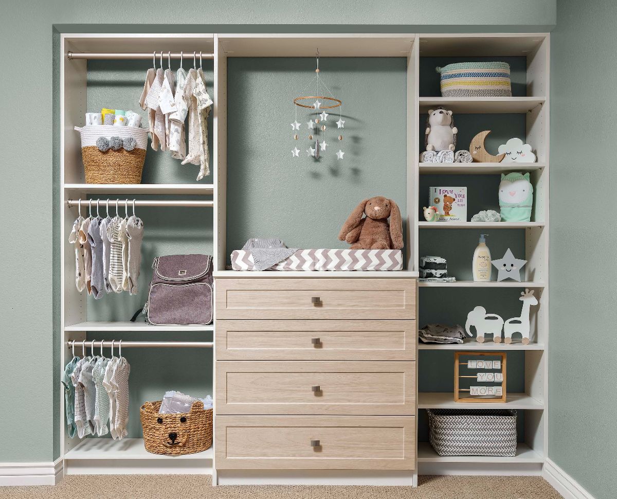 a kids' custom closet system with fawn finish filled with toys and clothes .