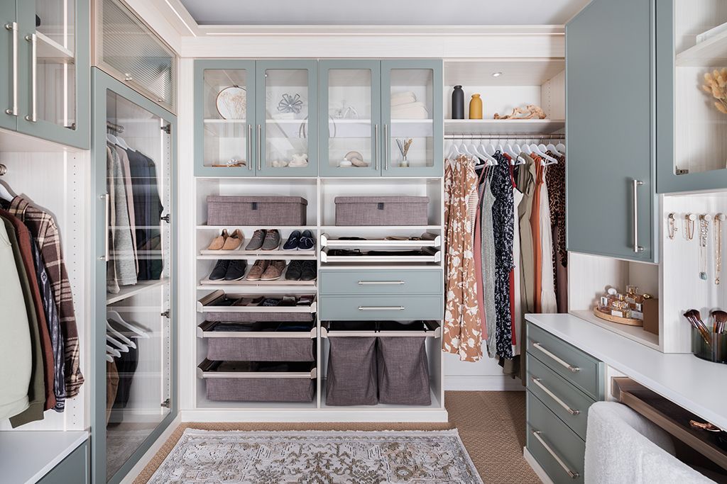 A walk in closet with lots of clothes and a rug.