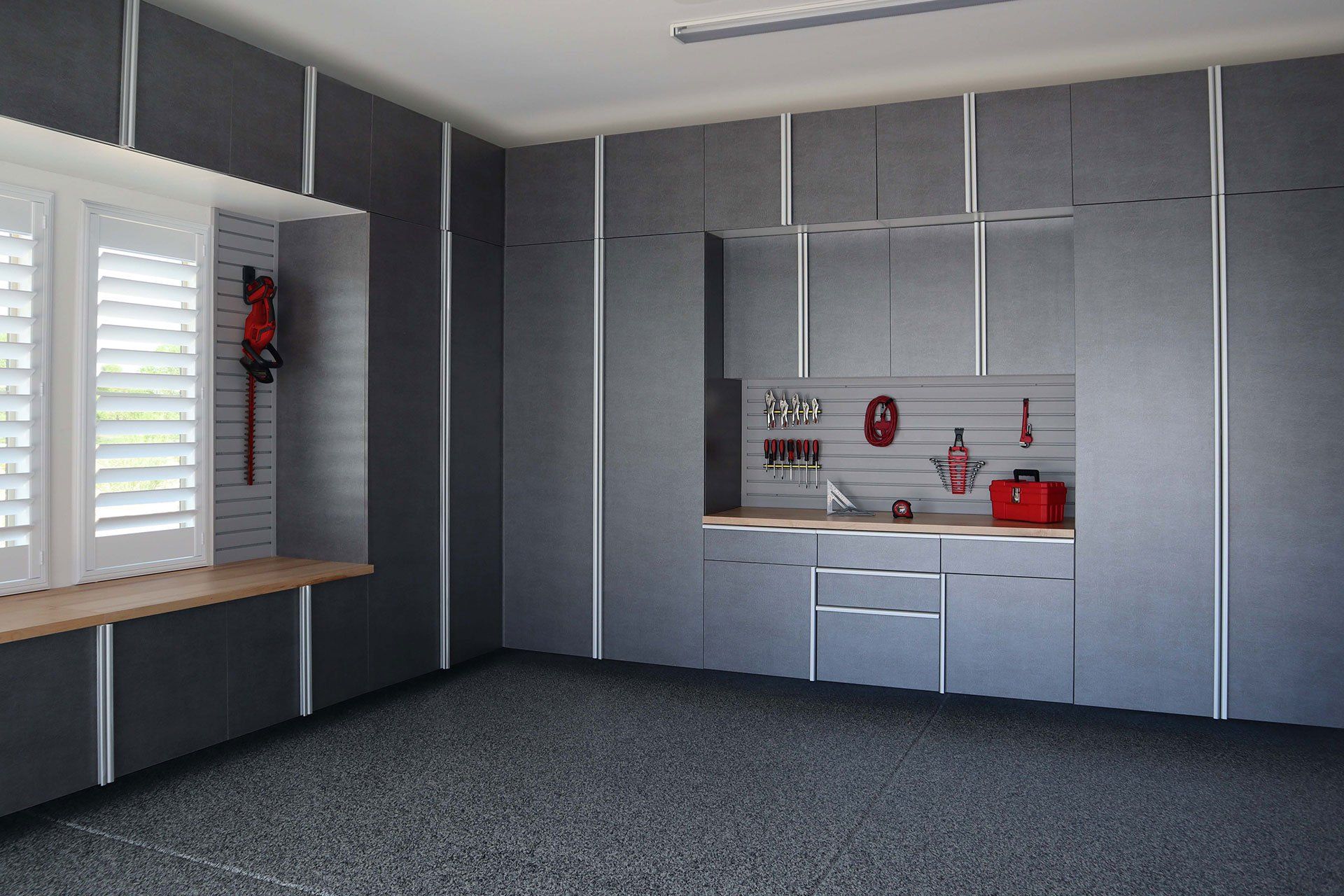 a garage with gray cabinets and slatwall organizer system