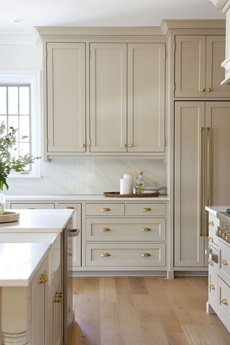 A kitchen with white cabinets , a sink , a stove and a refrigerator.