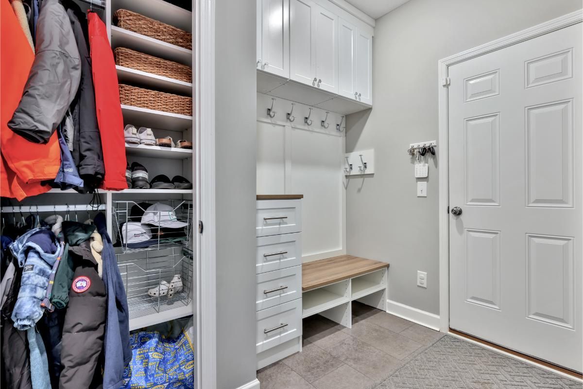 A mud room with a closet and a bench.