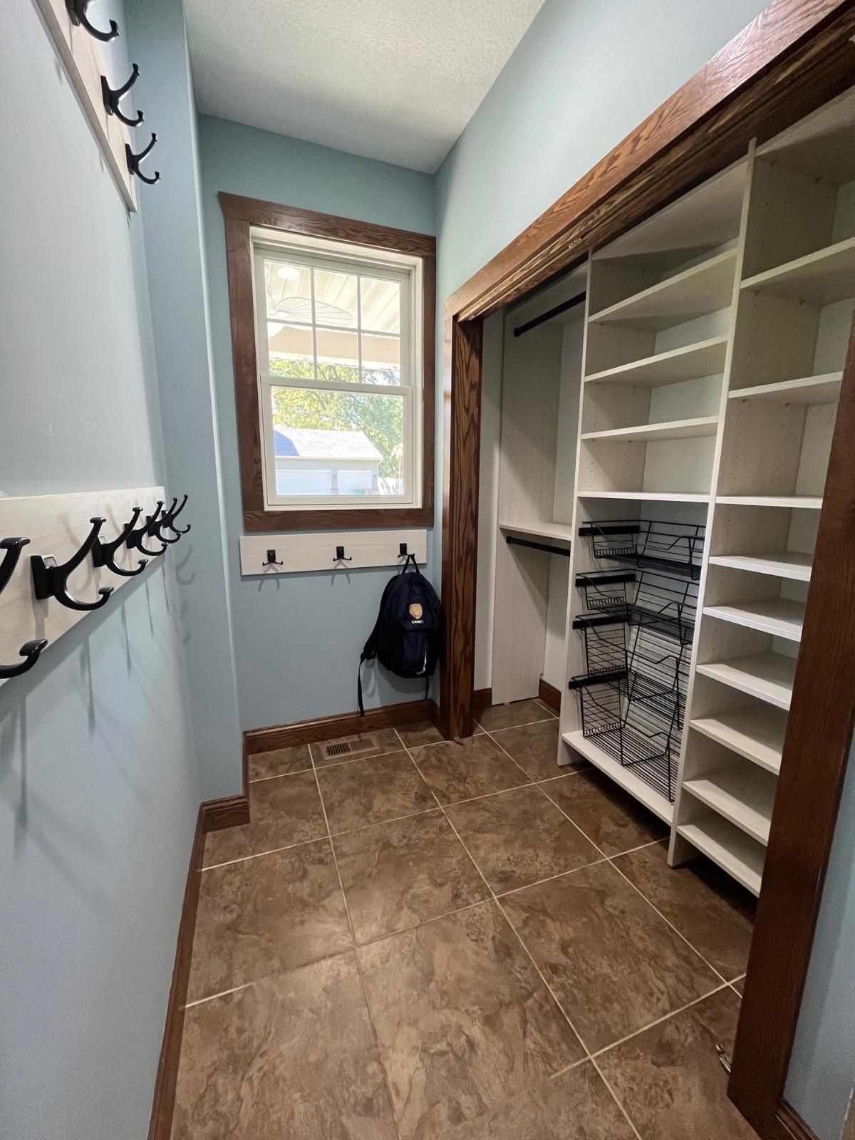 A walk in closet with lots of shelves and a window.