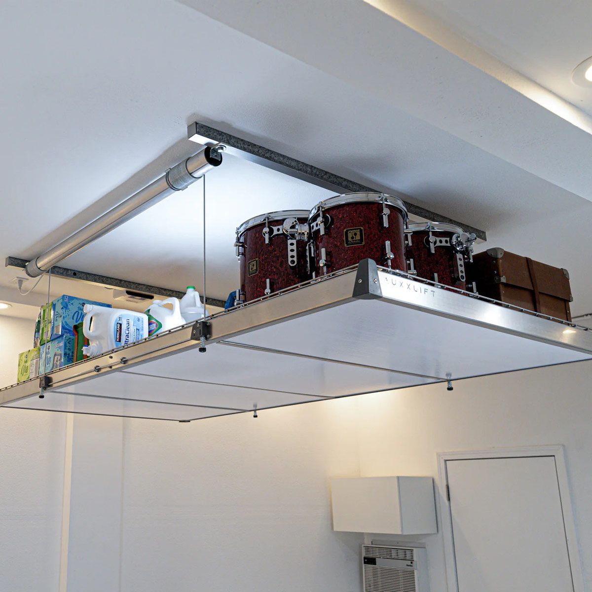 A drum set is hanging from the ceiling of a garage