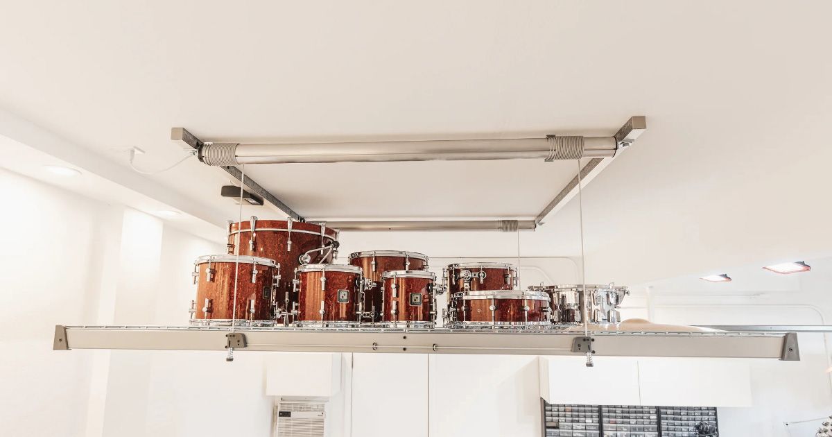 A drum set is on an overhead storage lift in a garage.