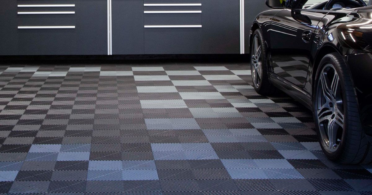 A car is parked in a garage with a swisstrax tile floor.