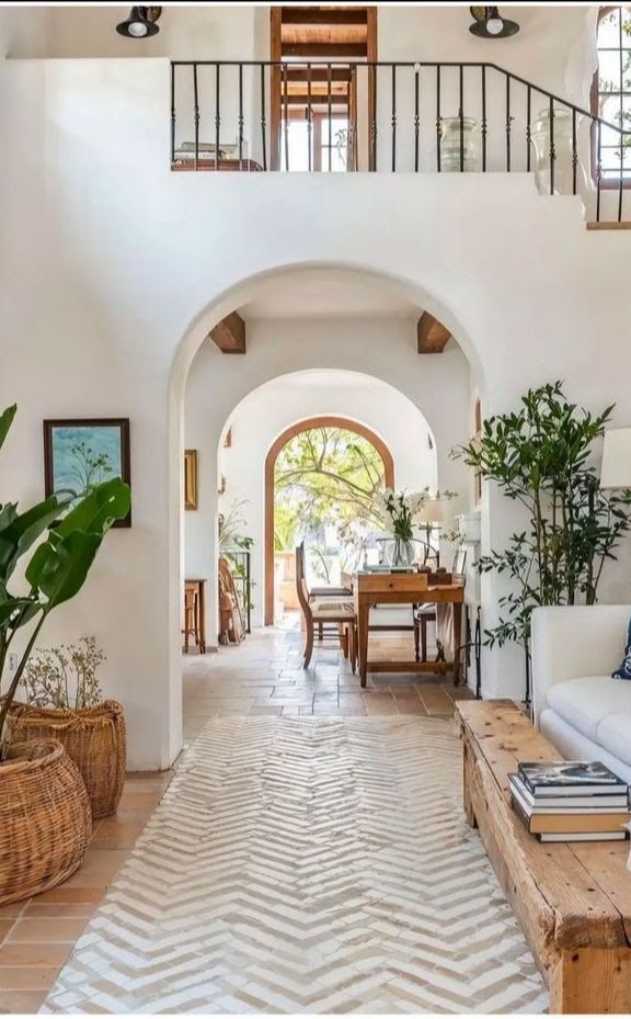 A bedroom with a bed , chairs , ottoman and lamp.