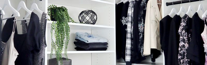 A walk in closet filled with lots of clothes and a rug.