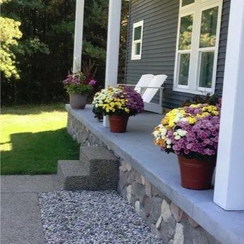 A porch with flowers in pots on it