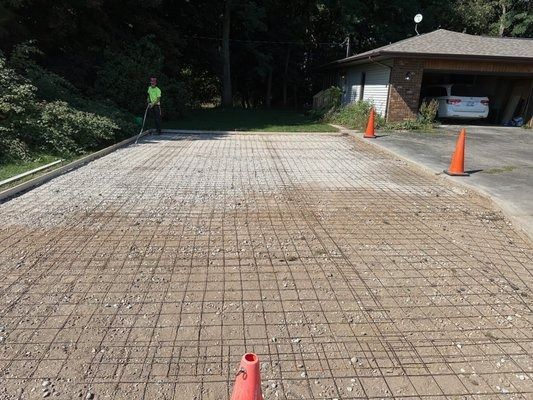 A concrete driveway is being built in front of a house.