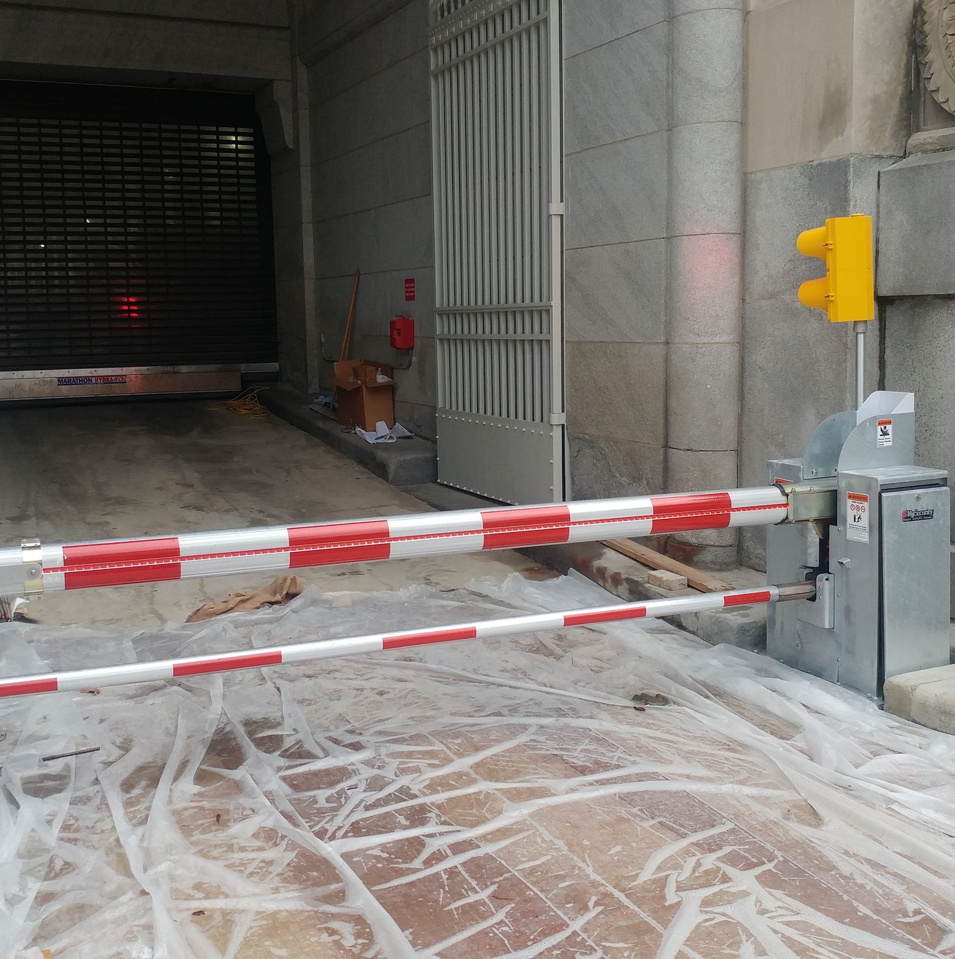 Blocked garage entrance with red-and-white barrier and wet, foamy pavement