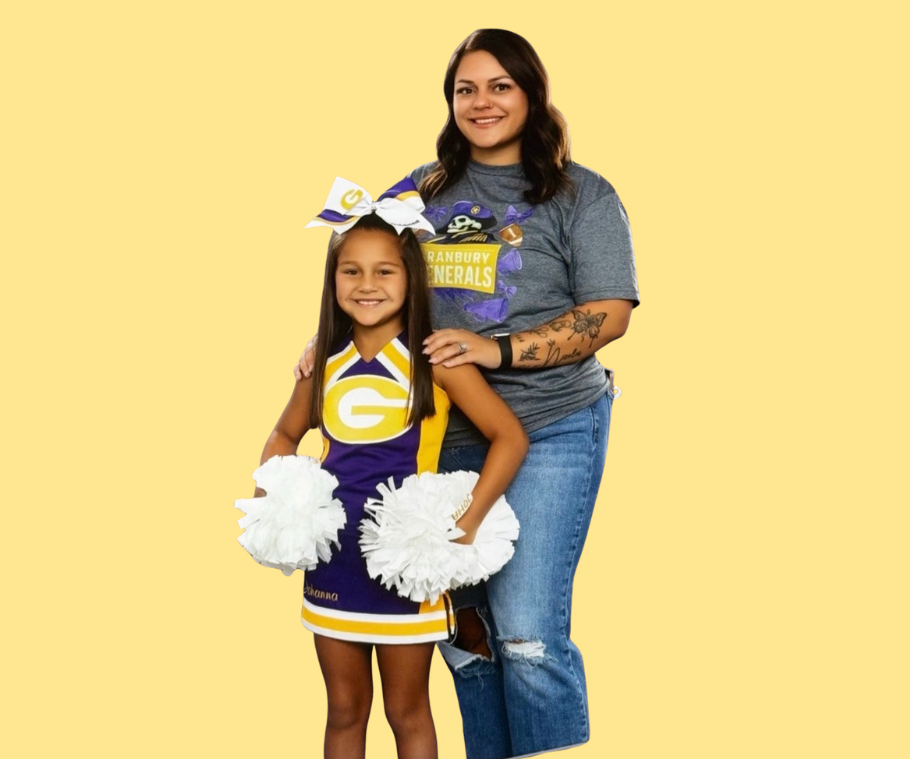 Man with crossed arms on a football field. He is wearing a blue polo shirt, khaki pants, and has a serious expression.