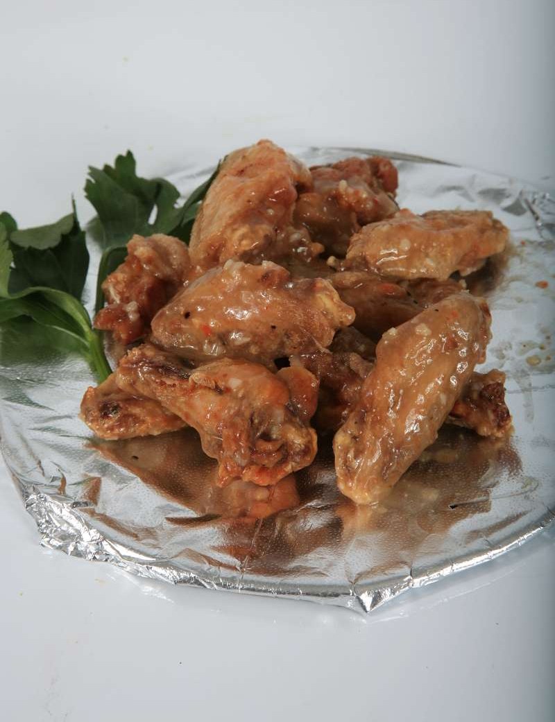 A glass plate topped with chicken wings and parsley