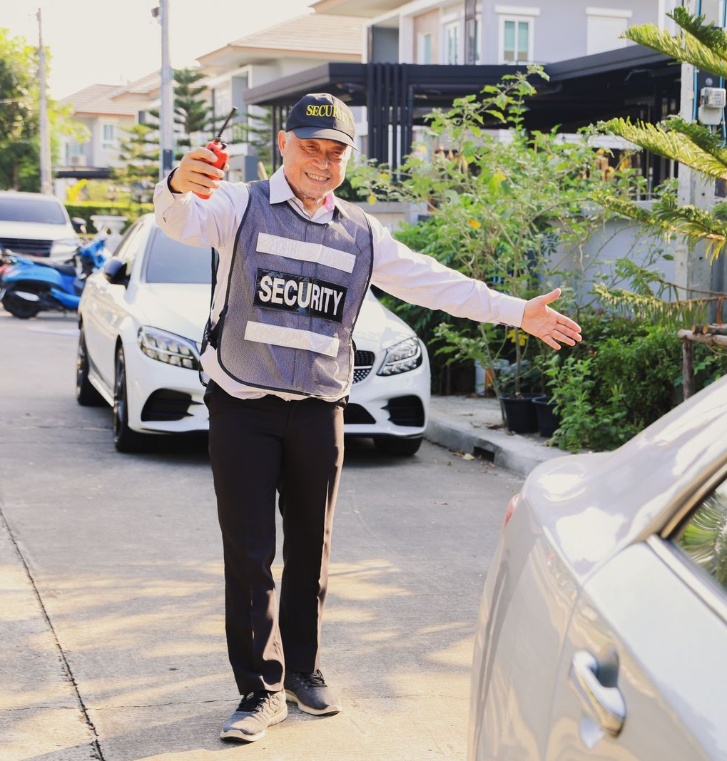 Security guard directing traffic on a residential street; wearing a 