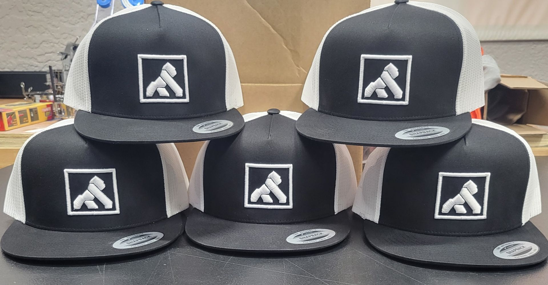 A group of black and white hats with the letter a on them