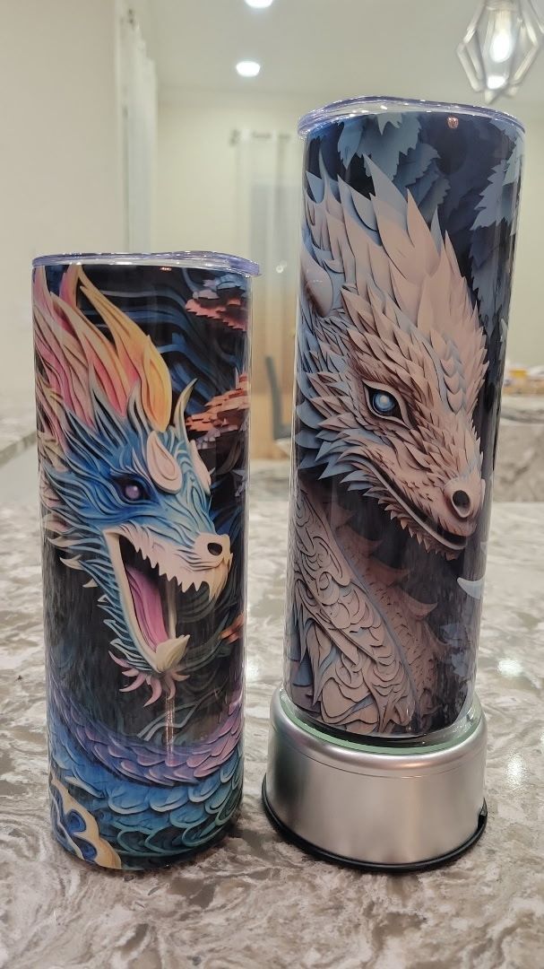 Two tumblers with dragons on them are sitting on a counter.