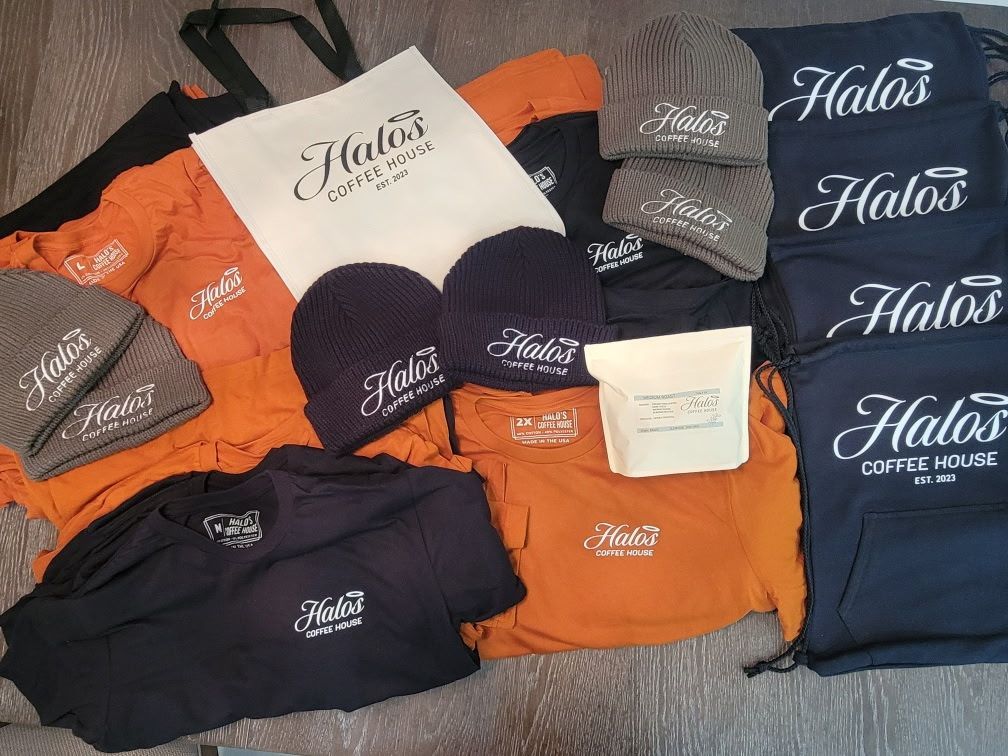 A bunch of shirts and hats are sitting on a table.