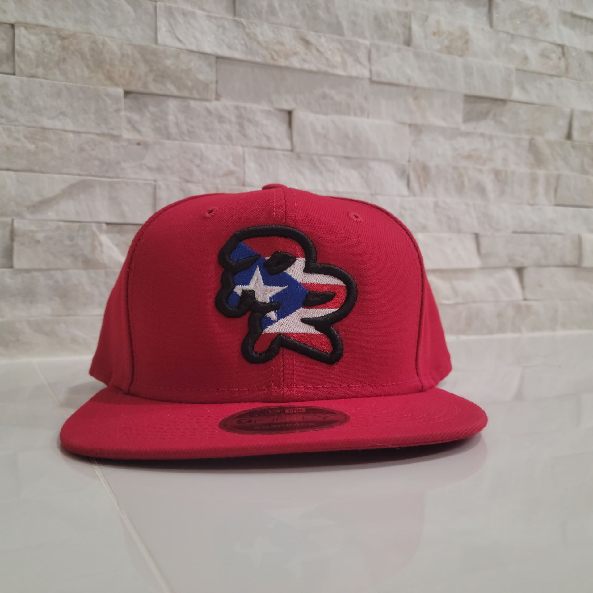 A red baseball cap with a puerto rico flag on it