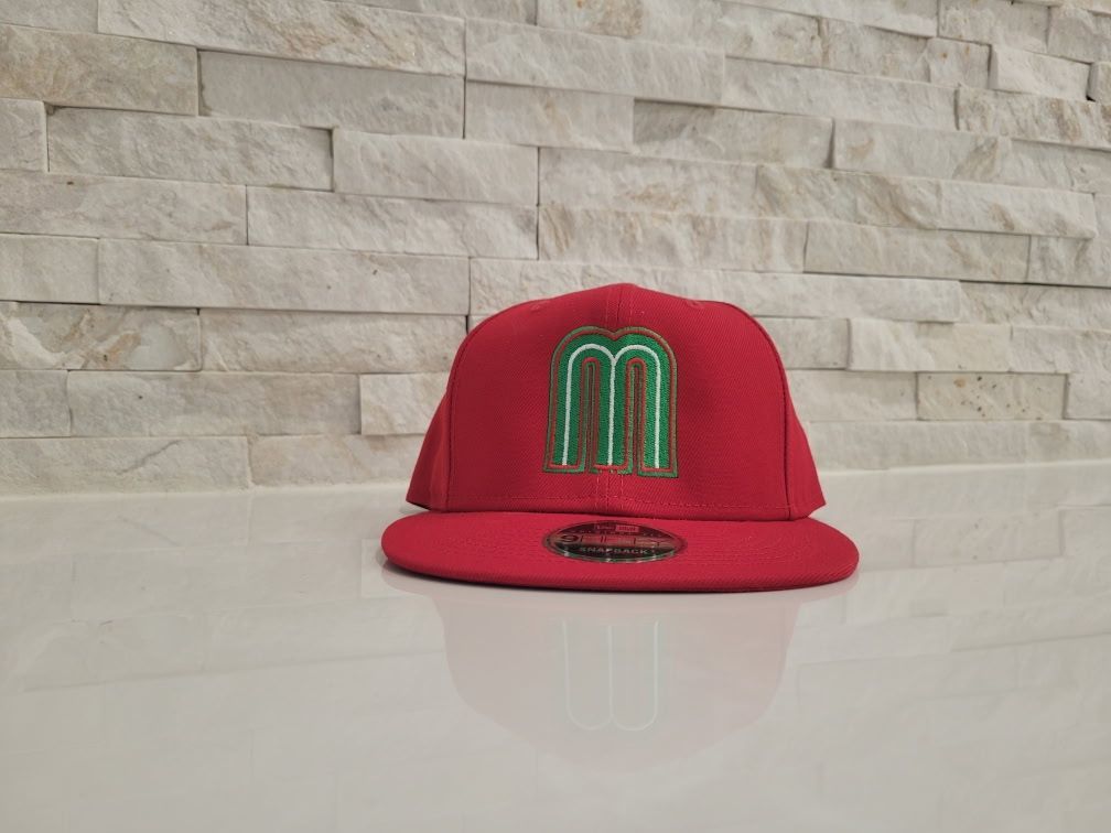 A red hat with a green letter m on it