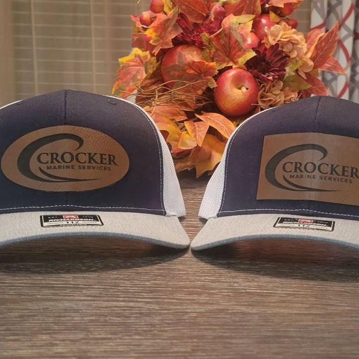 Two crocker hats are sitting on a wooden table