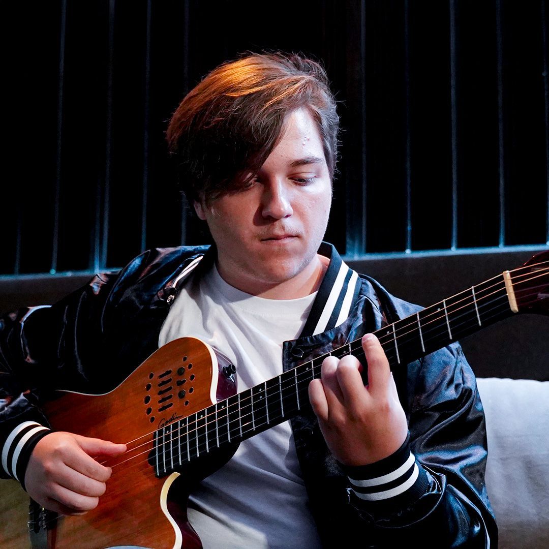 A girl playing guitar during a private lesson