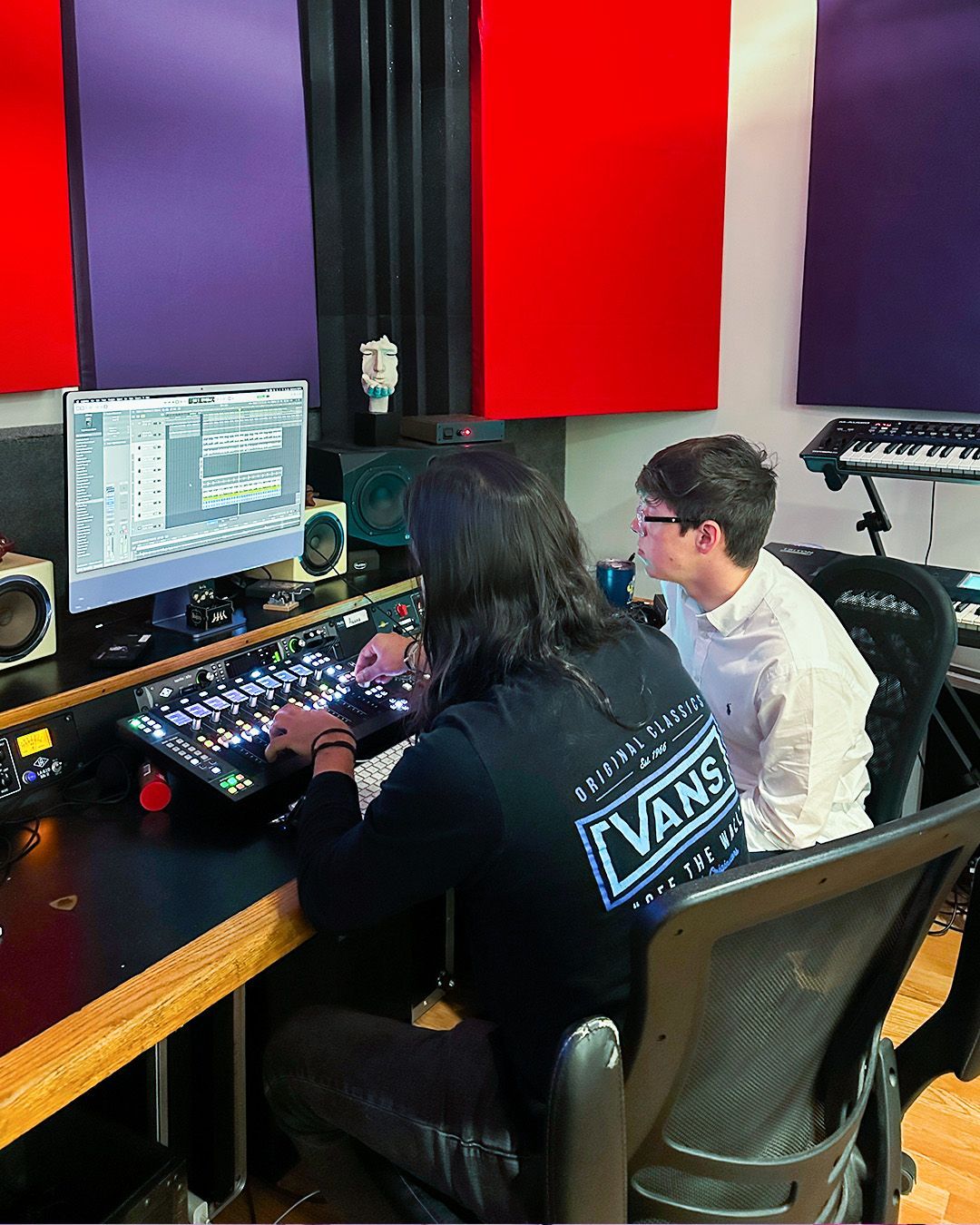 Kid with a headset in a music production studio during a private class