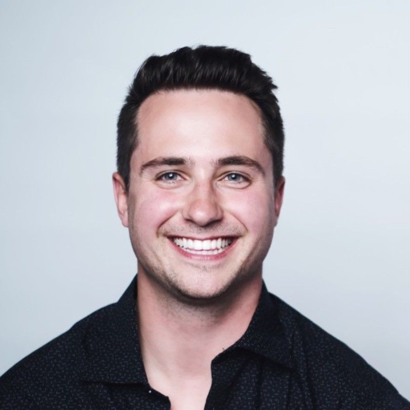 A man in a black shirt is smiling for the camera