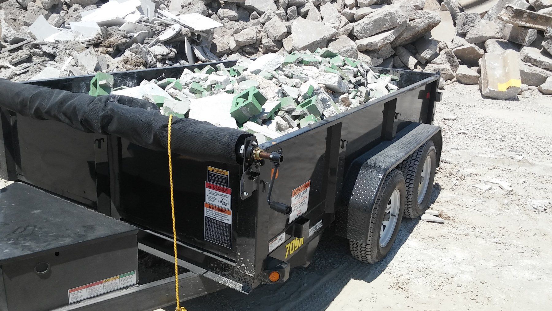 A dumpster with a lot of rocks in it
