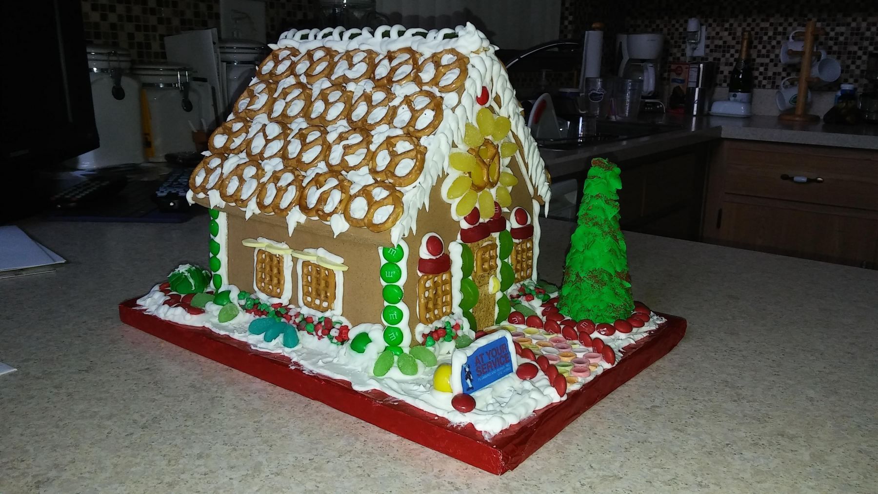 A gingerbread house is sitting on a table in a kitchen.