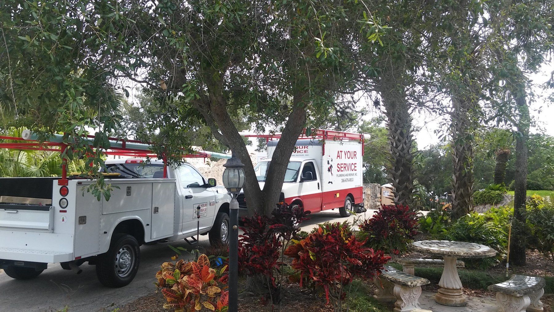 A red and white ambulance is parked next to a white truck.
