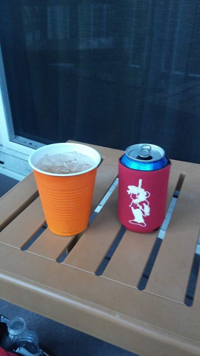 An orange cup and a blue can on a wooden table