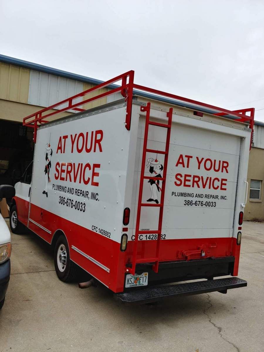A red and white truck that says at your service