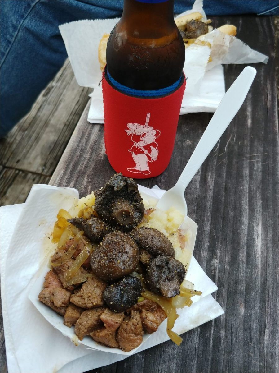 A bottle of beer sits next to a plate of food