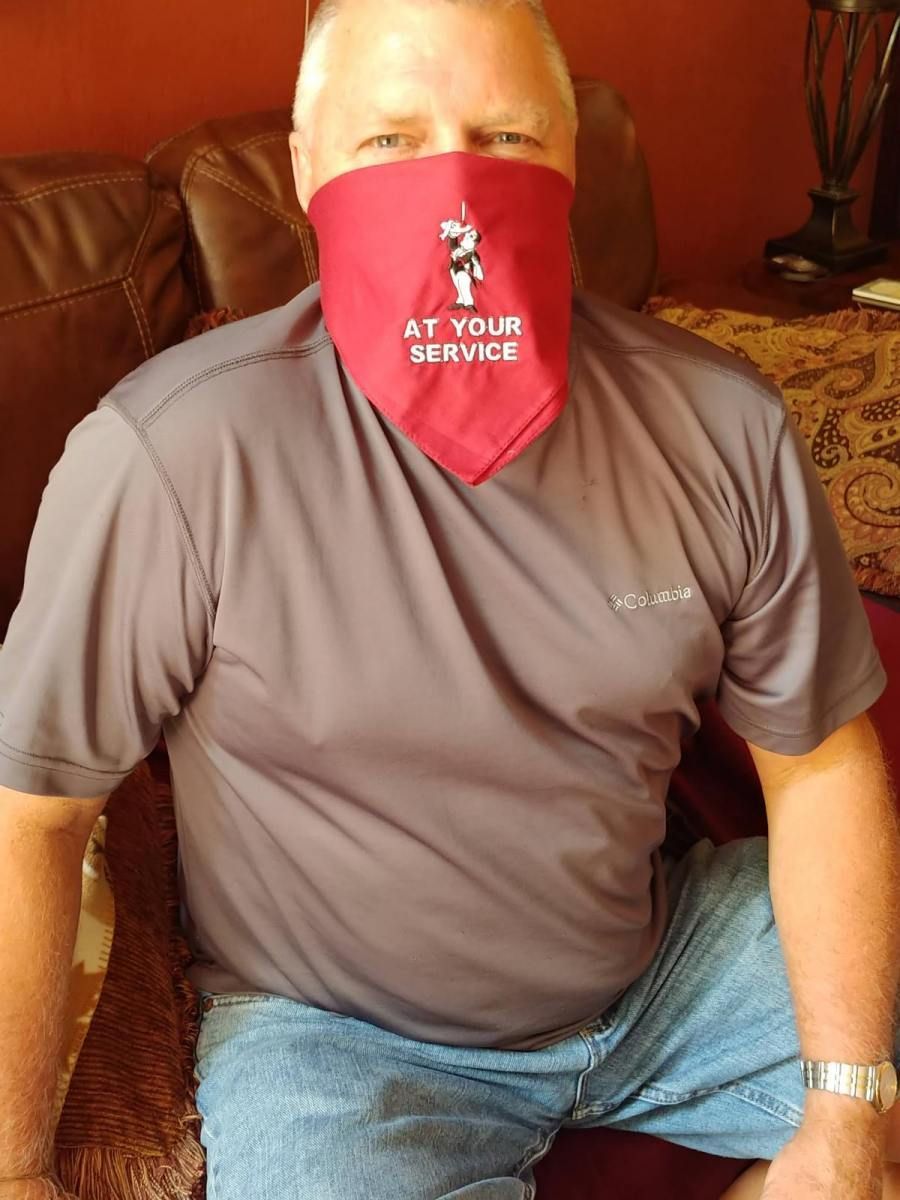 A man wearing a bandana that says at your service