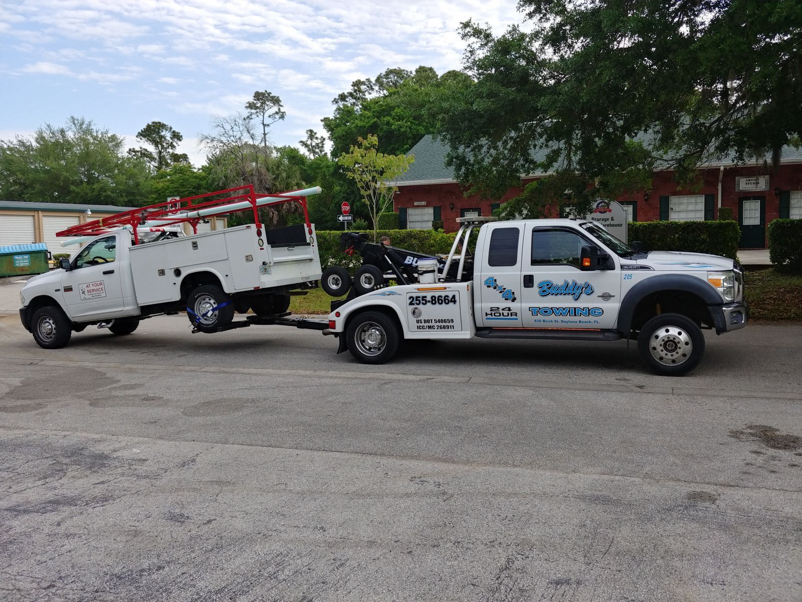 Two tow trucks are parked next to each other in a parking lot.