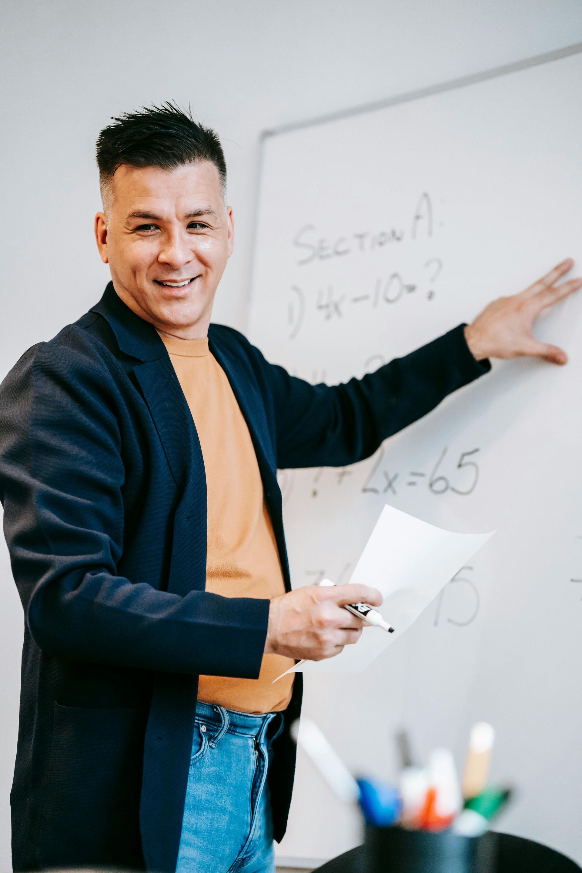 A man is standing in front of a white board with section a written on it