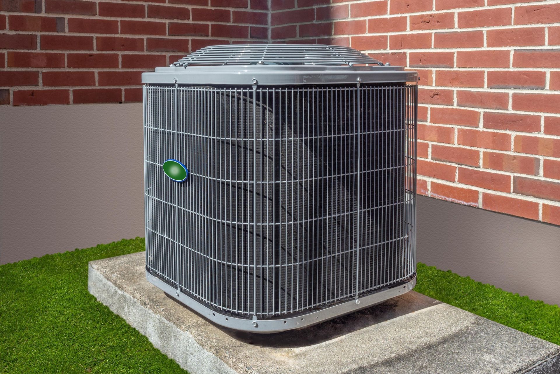 Outdoor air conditioning condenser unit beside a brick home during summer
