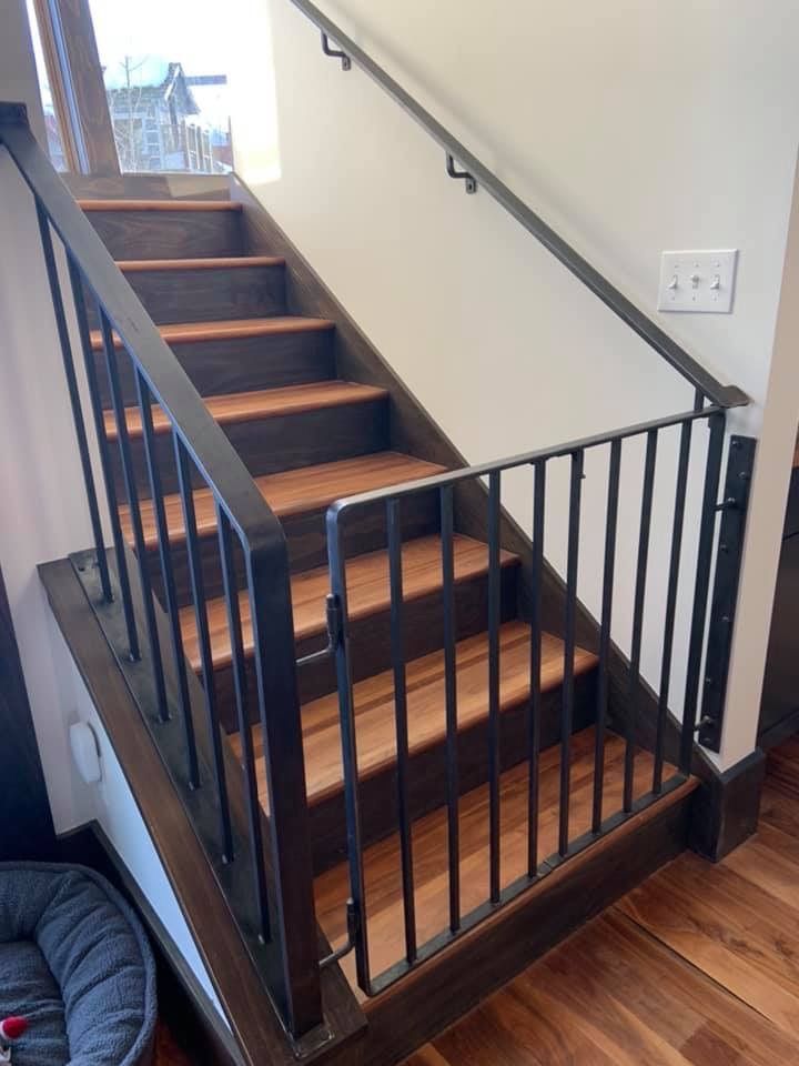 A wooden staircase with a metal railing in a house