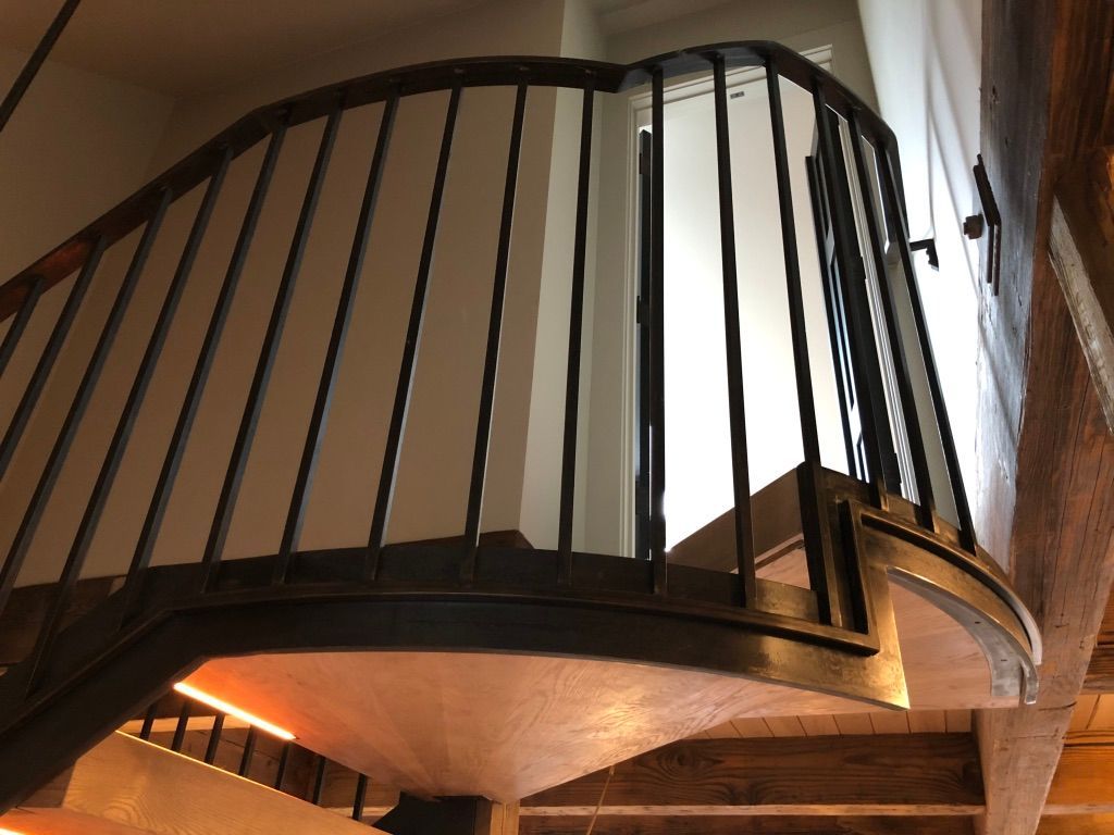 A close up of a spiral staircase with a metal railing.
