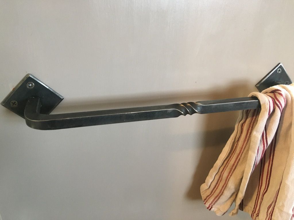 A towel is hanging on a wrought iron towel rack