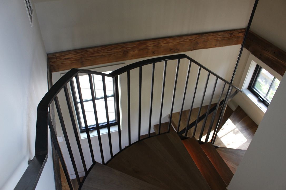 A spiral staircase with a metal railing and wooden steps