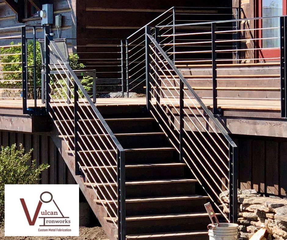 A set of stairs leading up to a wooden deck with a metal railing