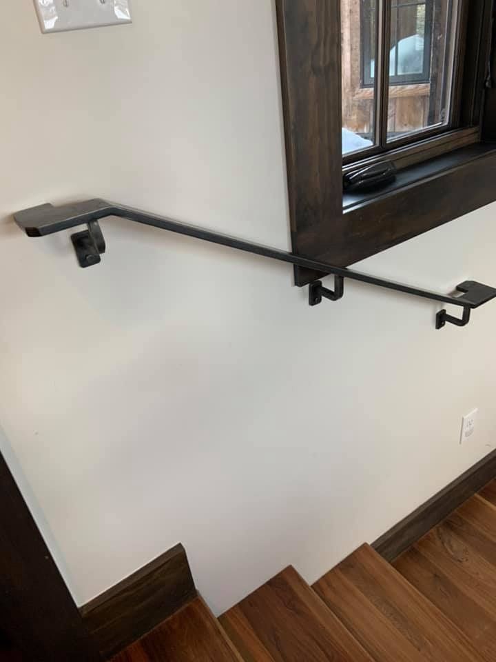 A close up of a railing on a staircase next to a window.