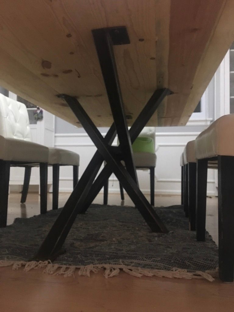 A wooden dining table with a black metal base