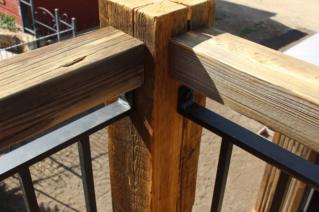 A close up of a wooden railing with a metal railing