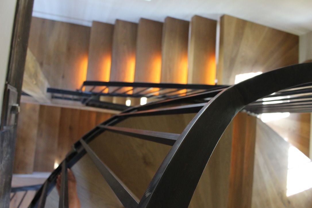 A spiral staircase with wooden steps and a metal railing