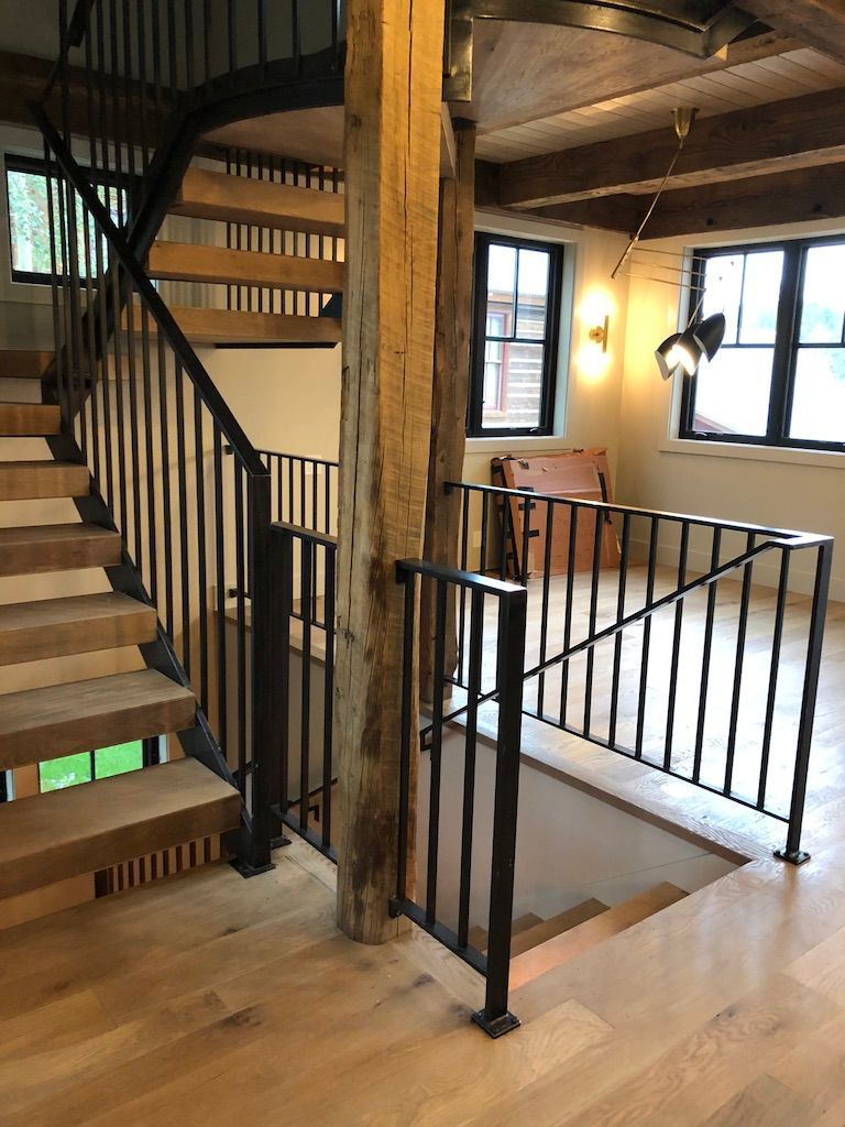 A wooden staircase with a metal railing in a house.