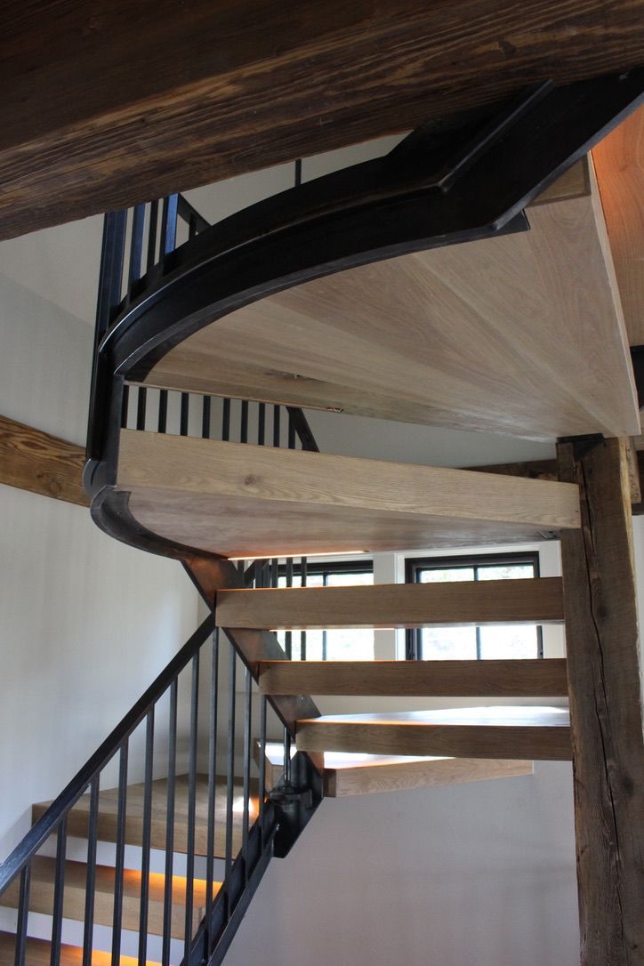 A spiral staircase with wooden steps and a metal railing